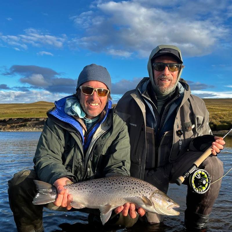 Two anglers holding a large brown trout